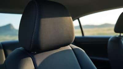 Gros plan d'un tissu de pavillon en train d'être repositionné dans un habillage intérieur de voiture.