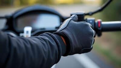 Gros plan sur des gants qui saisissent les poignées passager, mettant en avant le confort et la stabilité nécessaires en conduisant.